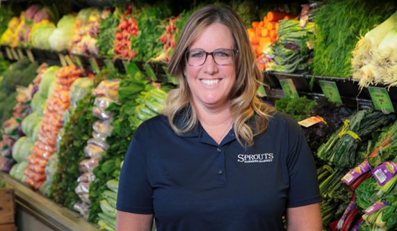 Sprouts manager in front of produce wet rack