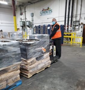 worker loading pallets of food for donation in warehouse