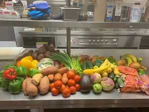 Fresh produce sits on a table in an industrial kitchen.