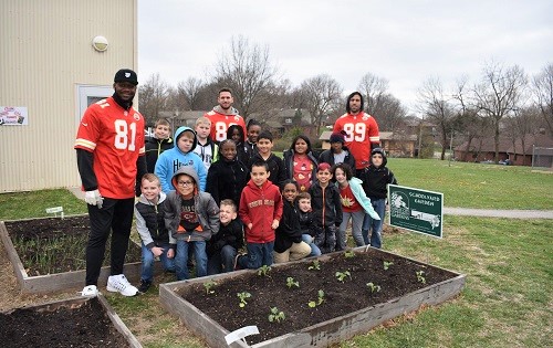 Students out in the garden with players from the Kansas City Chiefs.