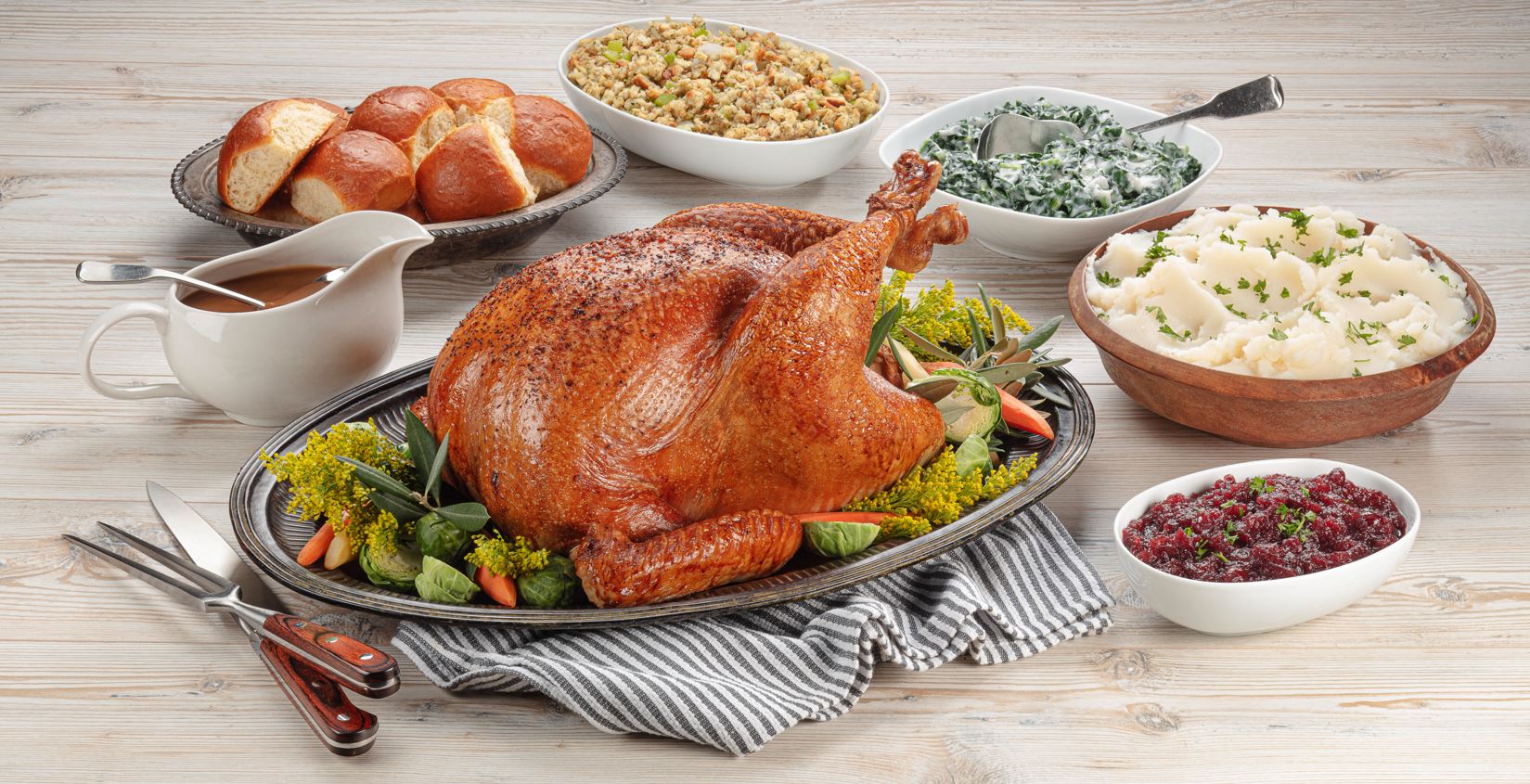 Thanksgiving meal with turkey and sides on a wooden table
