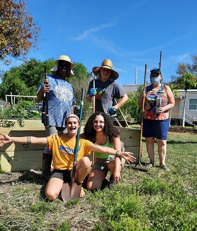 Adults smiling for a photo in a school garden in Florida