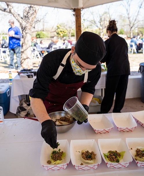 A high school contestant plating his team’s taco dish for the judges