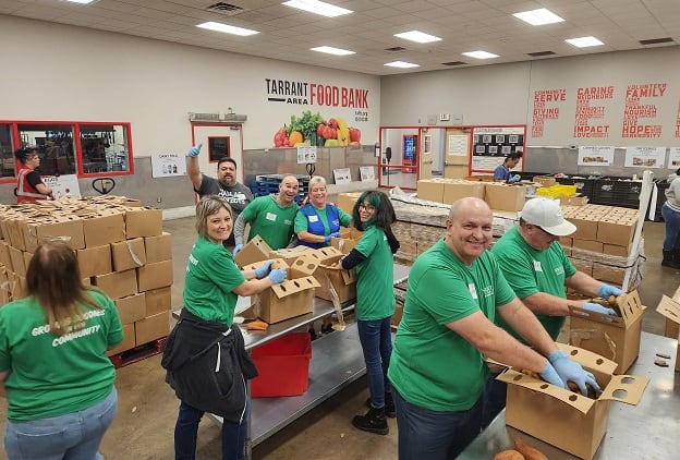 Happy volunteers pack food boxes for the community.
